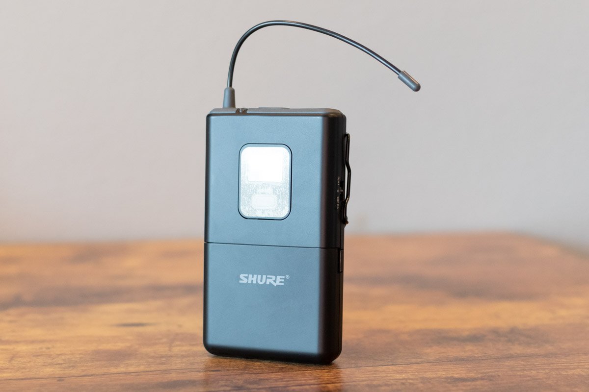 Shure wireless transmitter on a wooden surface with a neutral background