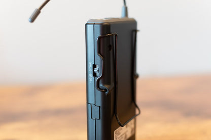 Black electronic device with a microphone on a wooden surface