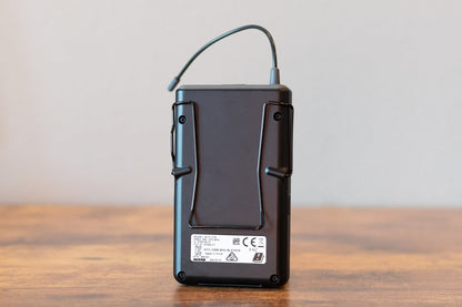 Black electronic device on a wooden surface with a neutral background
