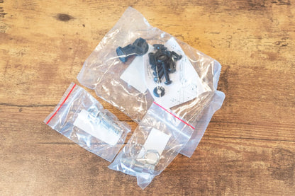 Mechanical components in clear plastic bags on a wooden surface