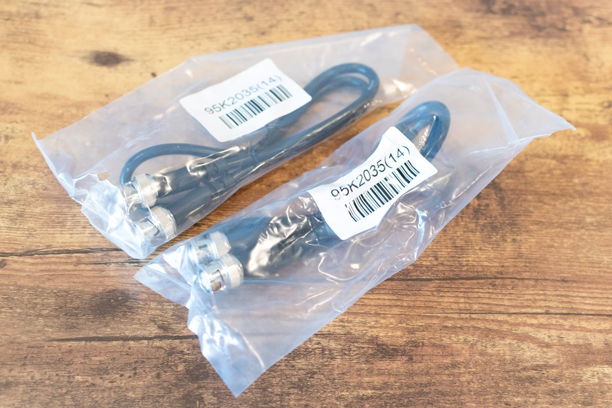 Two cables in a clear plastic bag on a wooden surface