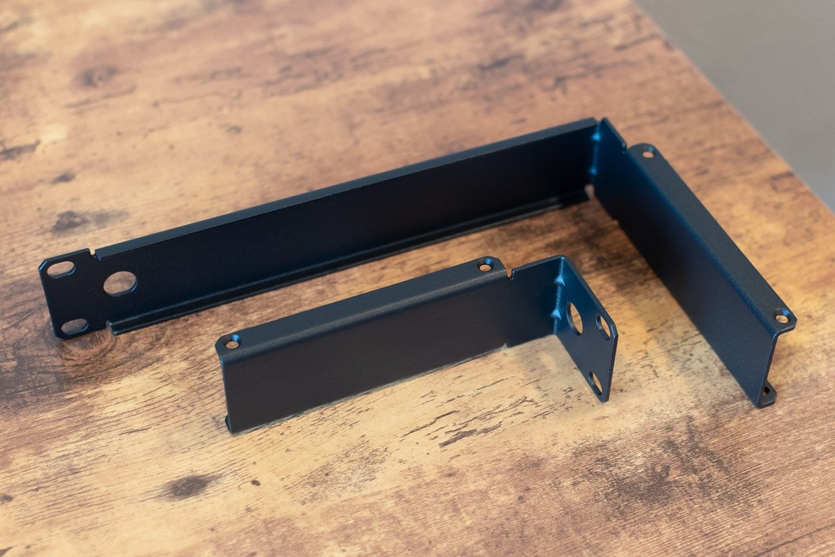 Two black metal brackets on a wooden surface